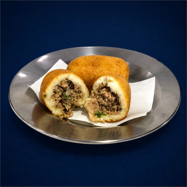 Bolinho de carne aberto mostrando o recheio.